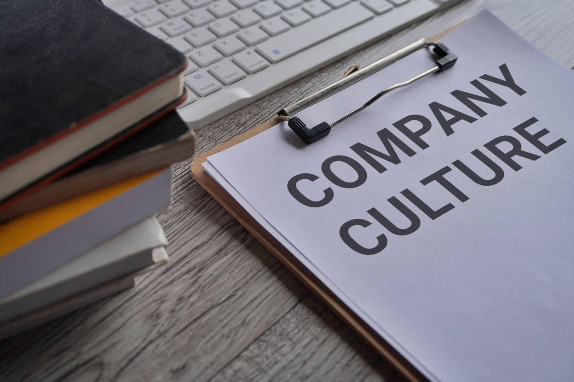 Paper clipboard with text COMPANY CULTURE on office desk